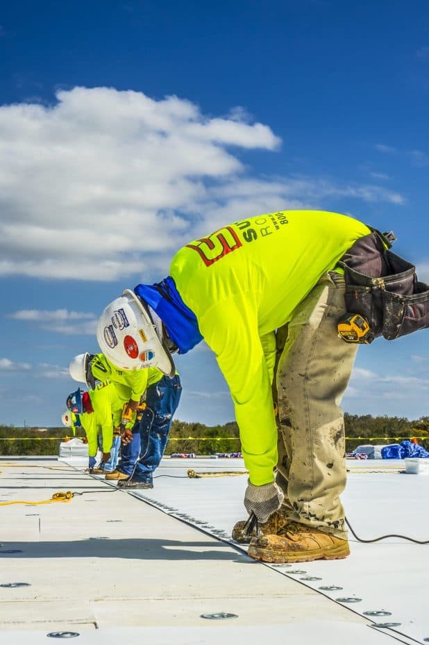 Commercial roofing crew installing a roof system